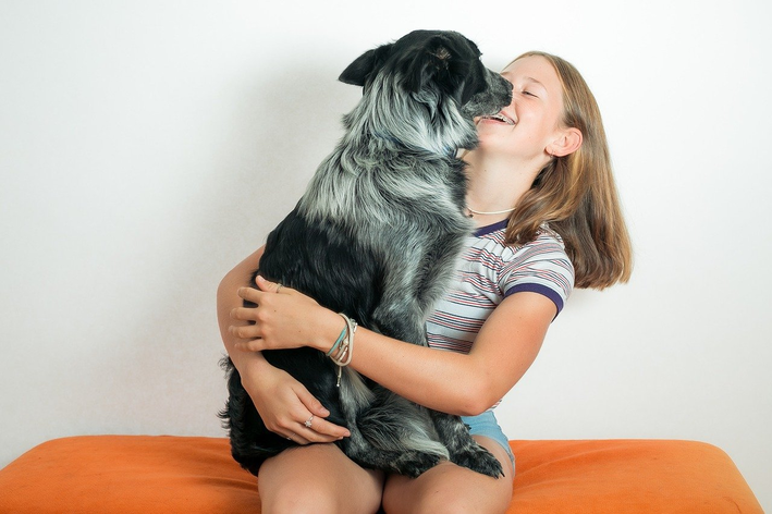 menina abraçando um cachorro