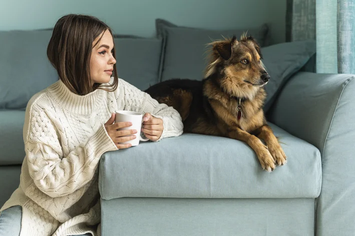 mulher tomando chá com cachorro do lado