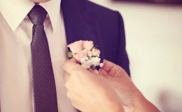 mulher colorando lapela floral em seu noivo
