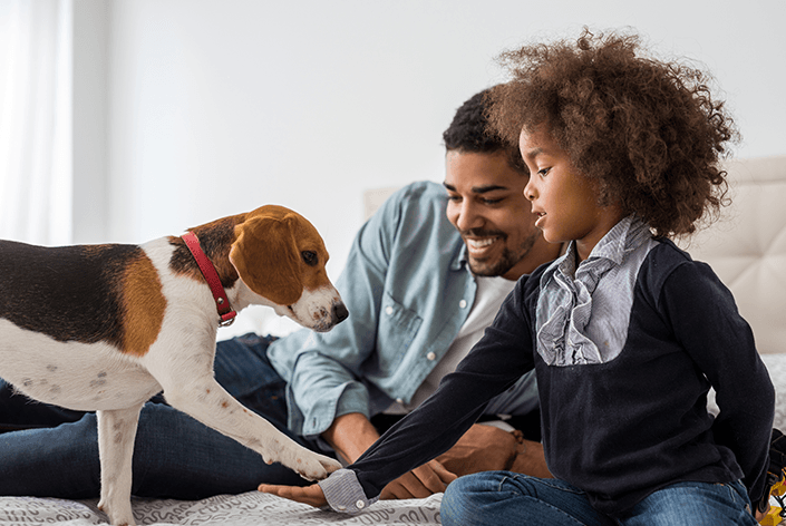Pai e filha com um cachorro beagle