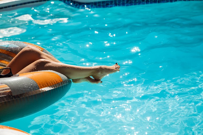 mulher relaxando em boia na piscina