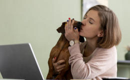 mulher beijando cachorro perto do computador adotar cachorro online